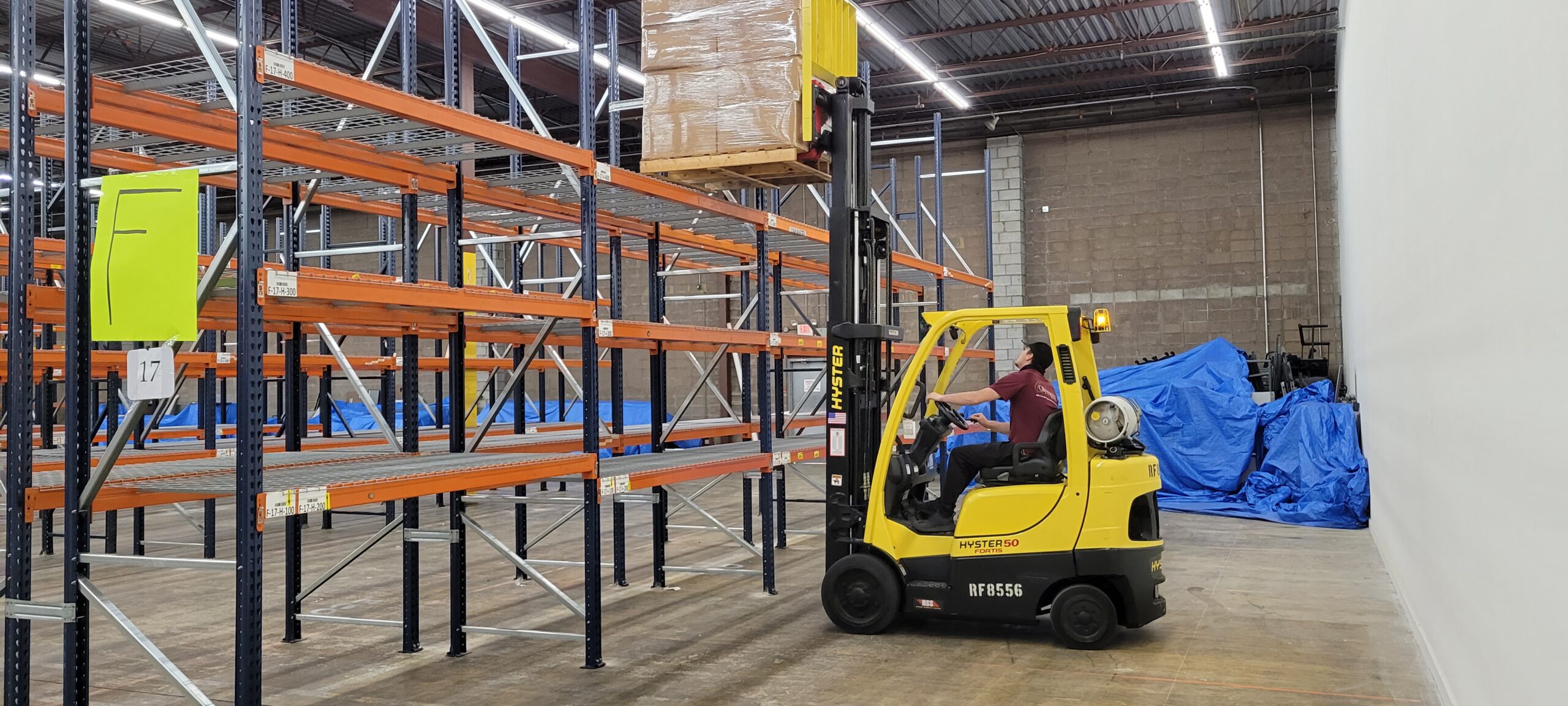 Olympia warehouse team member moving palletized storage