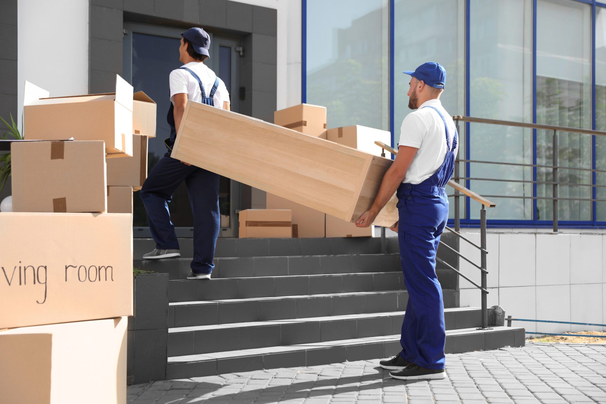 Professional movers carrying office furniture
