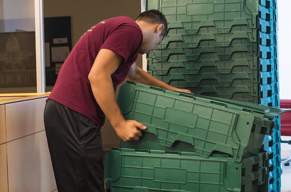 Stacked plastic moving crates ready for a commercial move