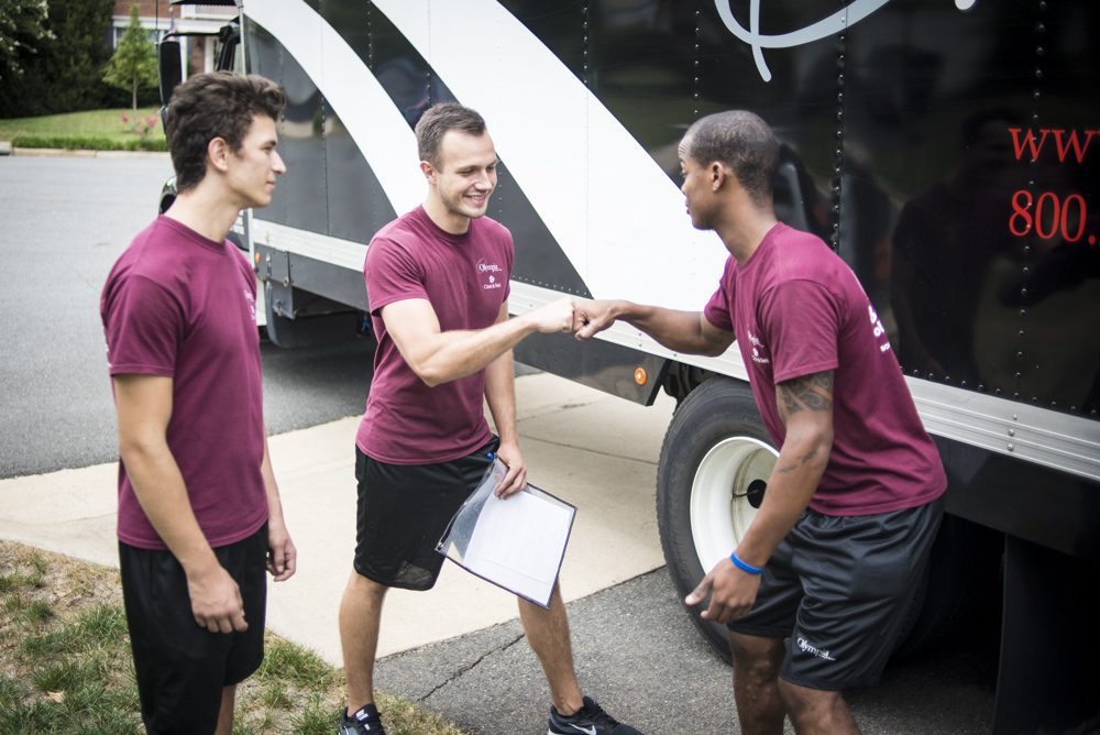 Olympia movers carrying a pad-wrapped couch