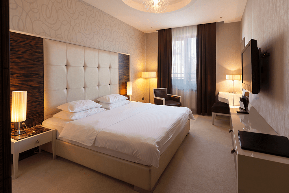 Furnished hotel room with beds, casegoods and fixtures
