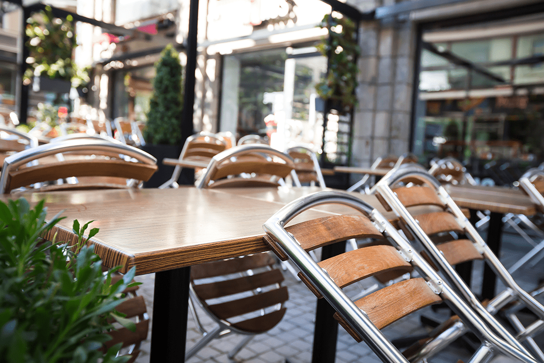 Outdoor patio chairs stacked at a restaurant