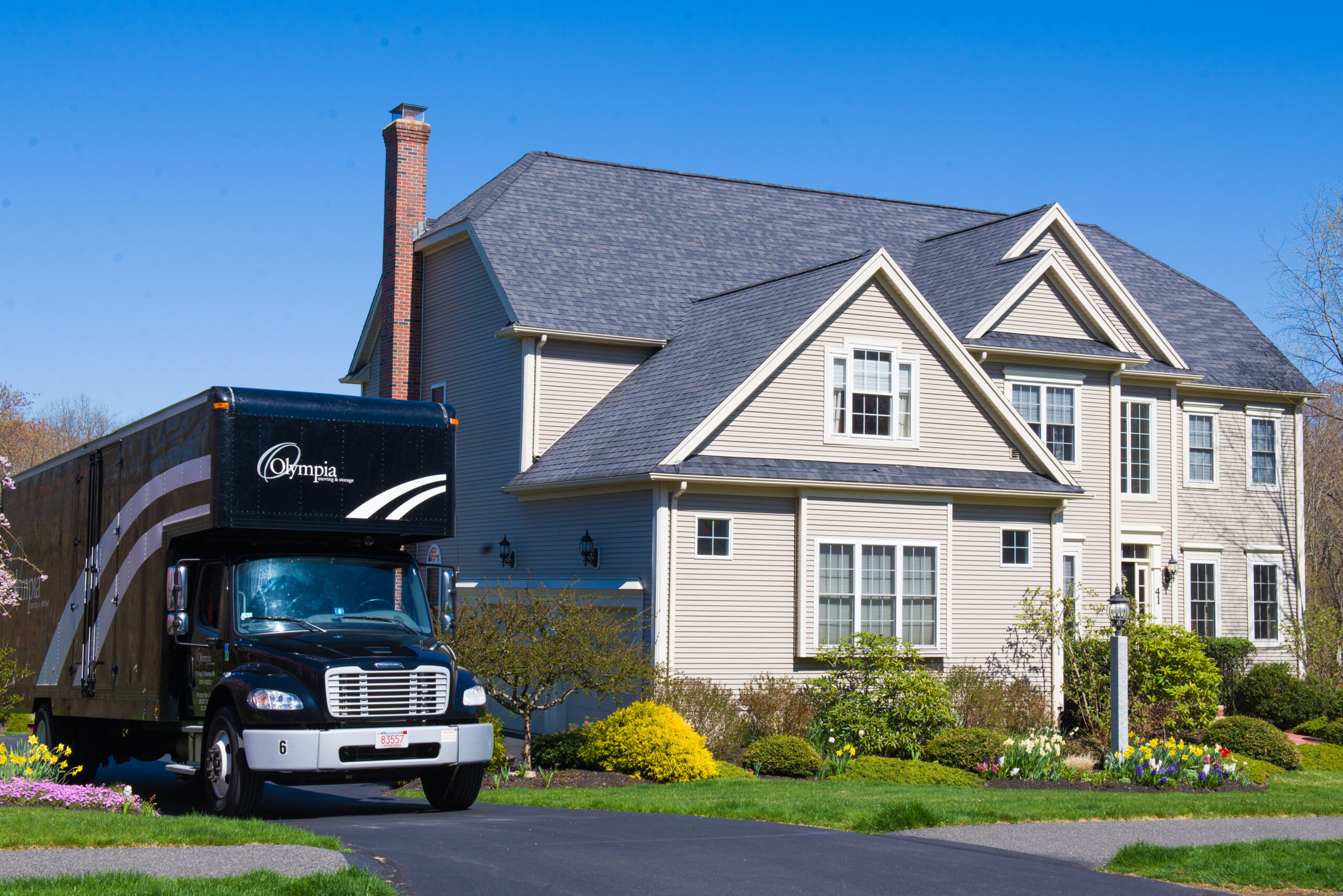 Olympia movers carrying furniture out of a single-family home