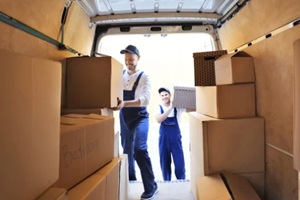 delivery men unloading moving boxes from car